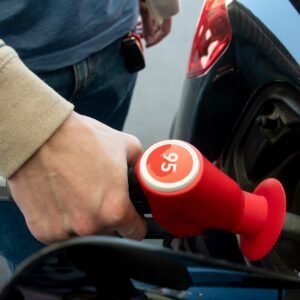 A man hand holding pump filling gasoline. Pumping 95 petrol into the tank