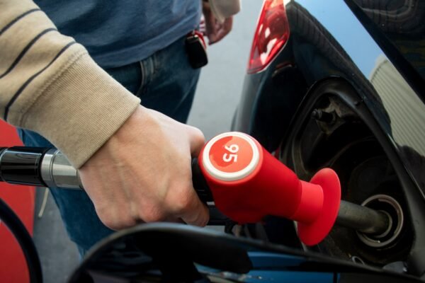 A man hand holding pump filling gasoline. Pumping 95 petrol into the tank